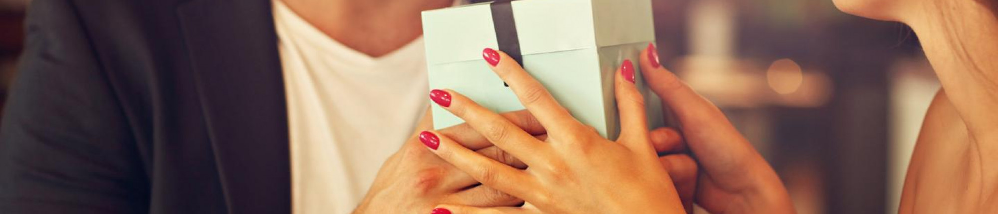 Man gives woman a jewellery gift over dinner - BAUNAT