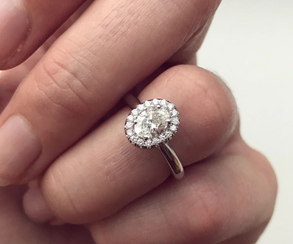 person wearing oval diamond engagement ring 