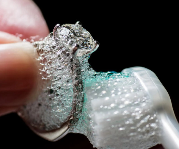 Person cleaning white golden diamond jewellery