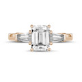 1.00 carat trilogy ring in red gold with an emerald cut diamond and tapered baguettes