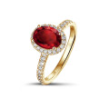 Halo solitaire ring in yellow gold with an oval ruby and small diamonds