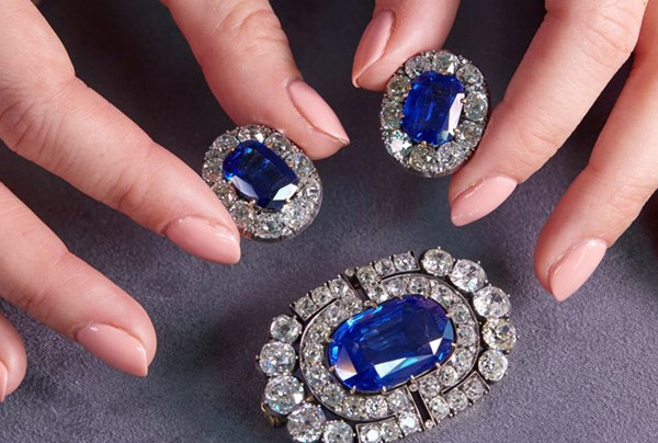 Hands with manicured nails showcasing sapphire diamond jewellery stored safely at home in a box