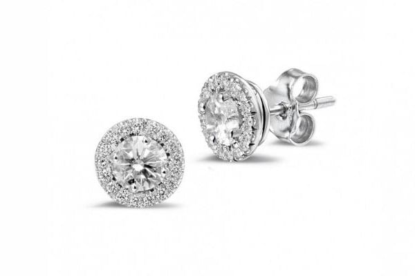 Three varieties of diamond halo earrings arranged elegantly, highlighting their diverse shapes and exquisite craftsmanship.