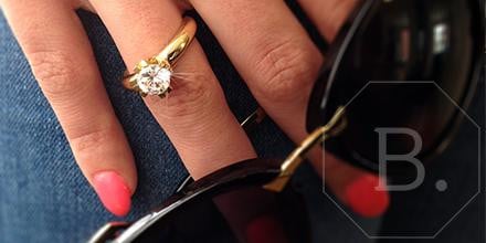 Person wearing golden diamond solitaire engagement ring