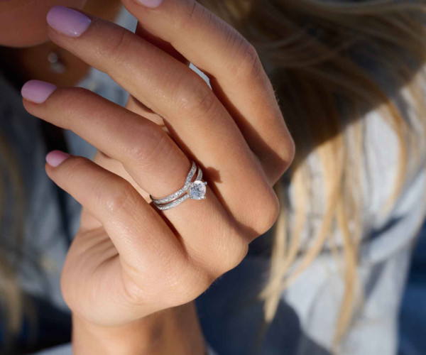 woman with pink nails wearing a diamond ring