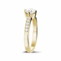 Anello solitario con diamante da 0,50 carati in oro giallo con diamanti laterali