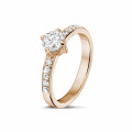Anello solitario con diamante da 0,70 carati in oro rosso con diamanti laterali