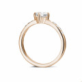 Anello solitario con diamante da 0,70 carati in oro rosso con diamanti laterali