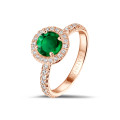 Anello solitario Halo in oro rosso con smeraldo rotondo e piccoli diamanti