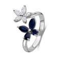 Anello combinato con fiori e farfalle con diamanti e zaffiri blu in oro bianco