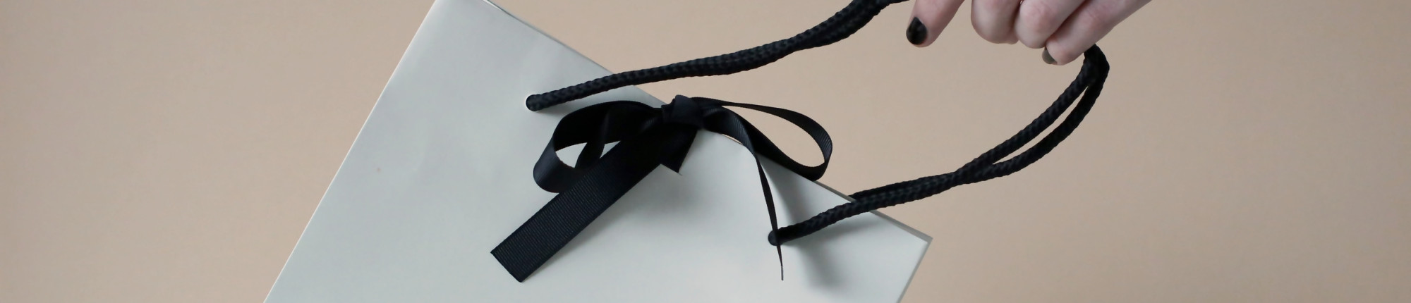 Donna con sacchetto regalo BAUNAT con nastro nero - BAUNAT
