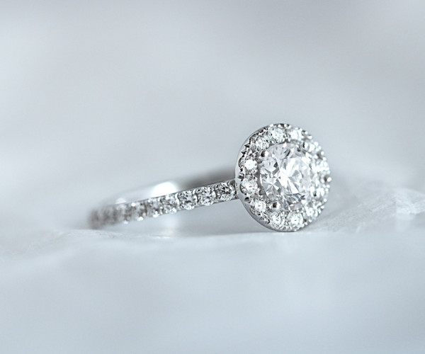Un bellissimo anello di fidanzamento in platino con un diamante scintillante, esposto su uno sfondo bianco immacolato.