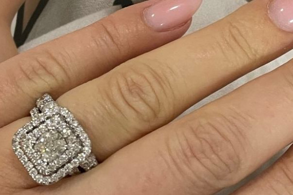 Persona che indossa un anello di fidanzamento con diamante taglio cuscino