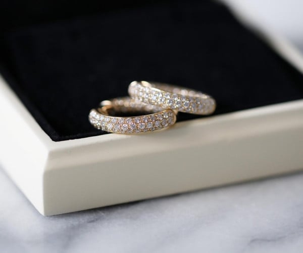 Due fedi nuziali in oro con diamanti su un cofanetto portagioie