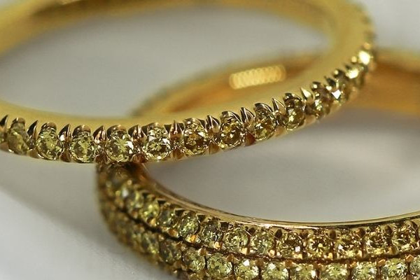 Due fedi nuziali in oro giallo con diamanti a full set su un panno