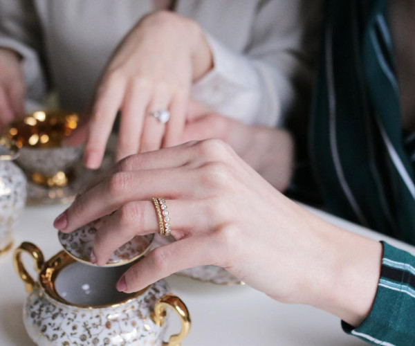 Donna che indossa un anello di fidanzamento con diamanti e un anello con diamanti sovrapponibili