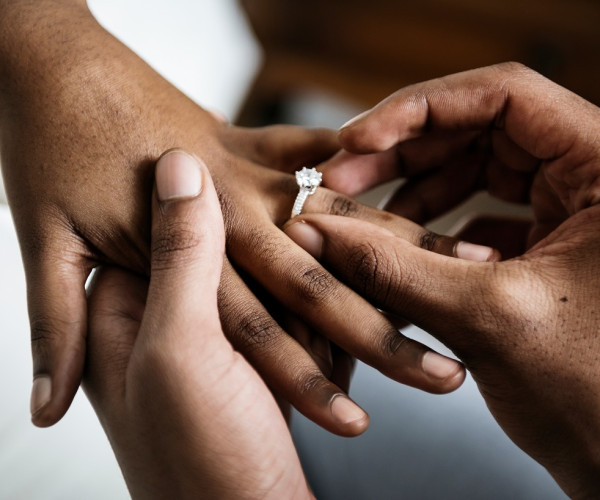 un uomo che mette un costoso anello di fidanzamento con diamante solitario al dito anulare della moglie