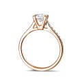 Anello solitario con diamante da 0,70 carati in oro rosso con diamanti laterali