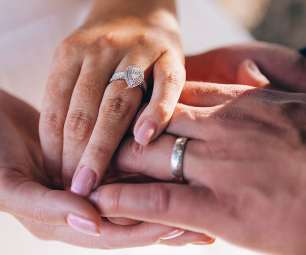 약혼 반지를 끼고 있는 커플의 손을 클로즈업하여 그들의 약속의 본질을 포착합니다