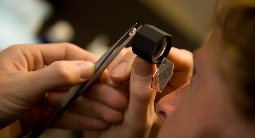 Diamant bestuderen met loep. BAUNAT verklaart het ontstaan van diamant op andere planeten.