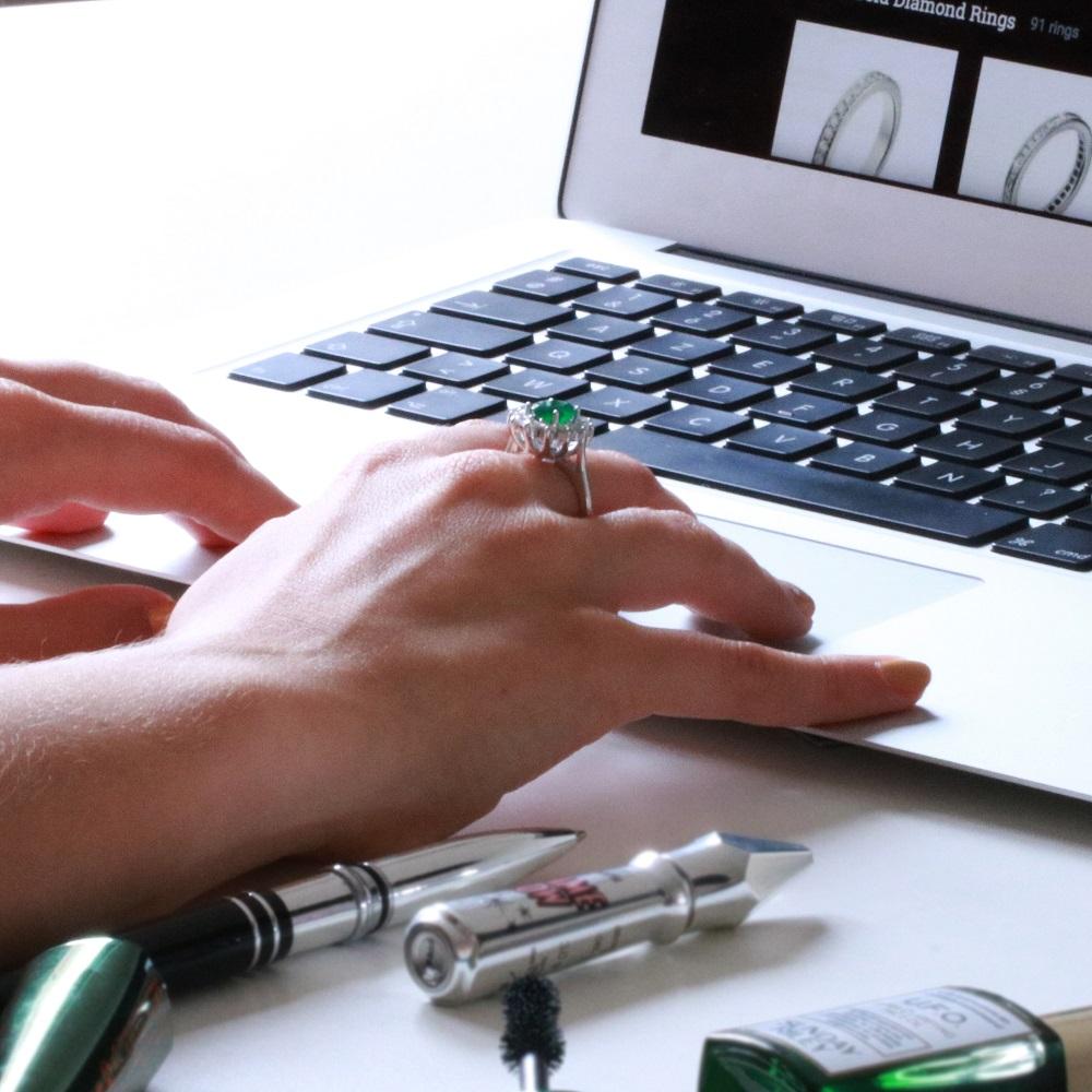 Vrouw met ring vergelijkt en koopt online verlovingsringen bij BAUNAT.