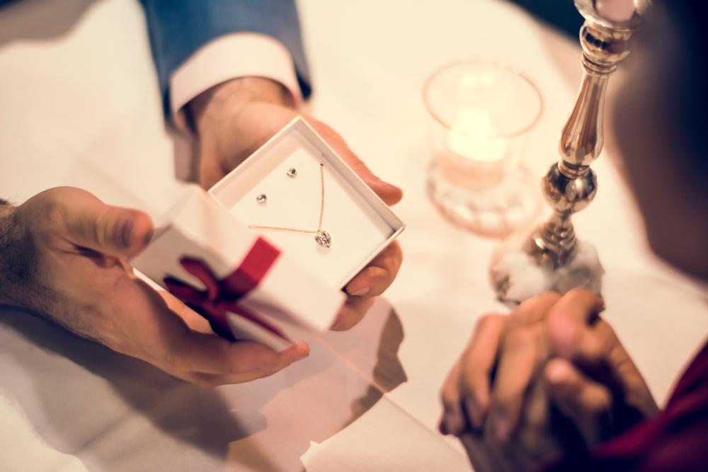 Vrouw krijgt ketting en oorbellen. Ook bij BAUNAT vindt u zo’n geschenk voor uw huwelijksverjaardag.