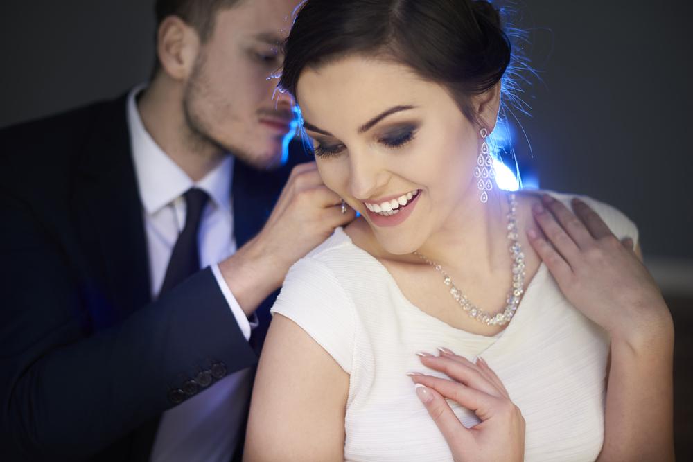 Man doet vrouw diamanten halsketting om, het perfecte cadeau voor haar van bij juwelier BAUNAT. 