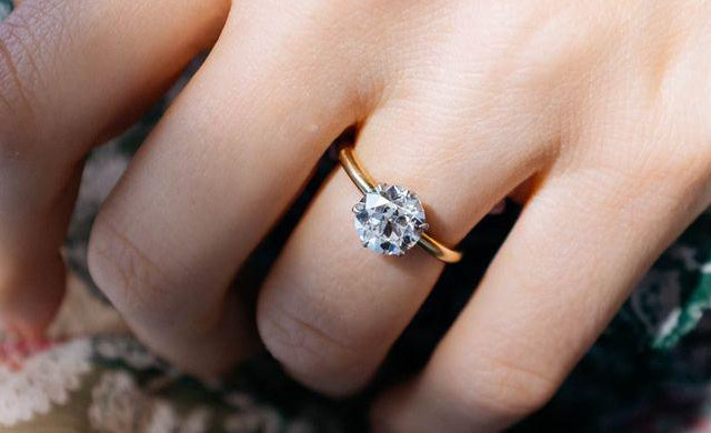 Woman wears yellow gold ring with a brilliant prong setting - BAUNAT
