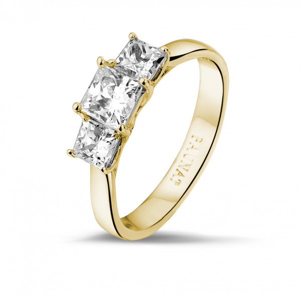 elegant yellow gold engagement ring with three princess cut diamonds.