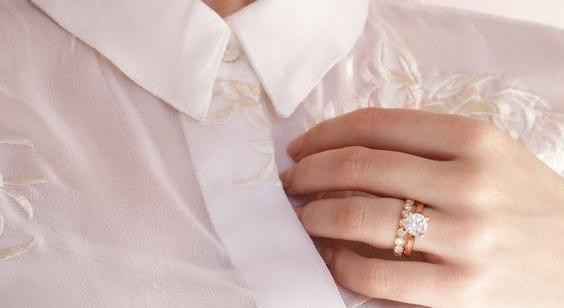 女仕拿着两只钻石戒指。 BAUNAT 求婚戒指上的钻石克拉重量。