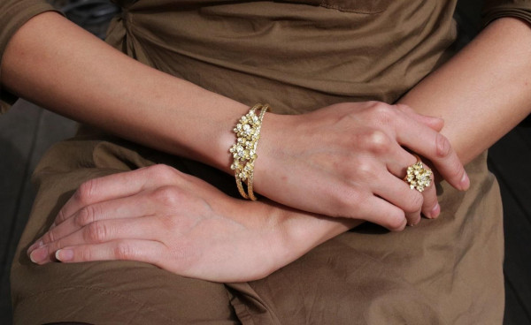 women wearing a high-quality bracelet with a yellow gold clasp - Designer bangle in gold with flowers, set with diamonds