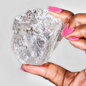 BAUNAT - a woman holding The Lesedi La Rona Diamond, one of the largest colourless diamonds in the world