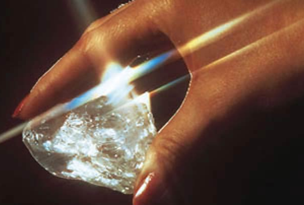 BAUNAT - a woman holding the Star of Sierra Leone diamond radiating a bright light
