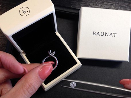 a woman holds a diamond ring, symbolising a significant investment in gold jewellery