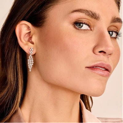 woman wearing elegant long drop earrings featuring sparkling white diamonds that catch the light beautifully