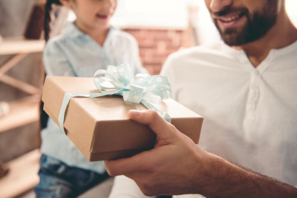 Un uomo riceve un regalo per la festa del papà da suo figlio. Scegli un regalo originale per la festa del papà dal gioielliere BAUNAT.