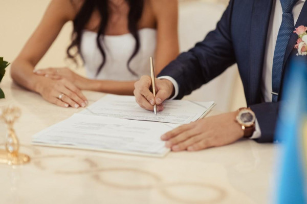 BAUNAT - Coppia che firma il certificato di matrimonio. Sposarsi all'estero è legale. – BAUNAT