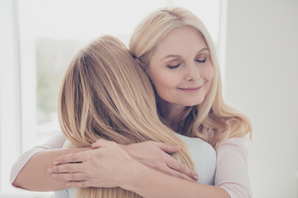 Una madre che abbraccia sua figlia nel giorno della festa della mamma - BAUNAT