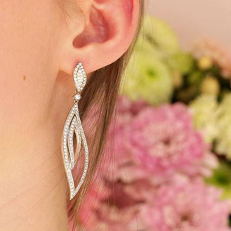 Una donna che sfoggia lunghi orecchini con diamanti, aggiungendo un tocco di eleganza al suo look.