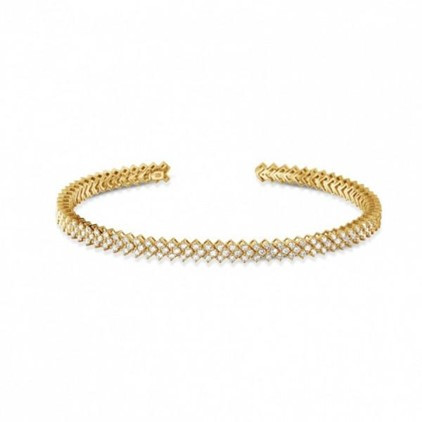 Lussuoso bracciale rigido in metallo oro giallo con diamanti abbaglianti incastonati.