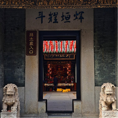 A Chinese temple stands tall, with a majestic lion statue guarding its entrance, showcasing traditional Chinese culture