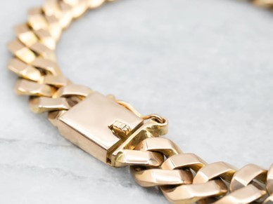 A gold chain bracelet featuring a secure box clasp, elegantly designed for a sophisticated look.