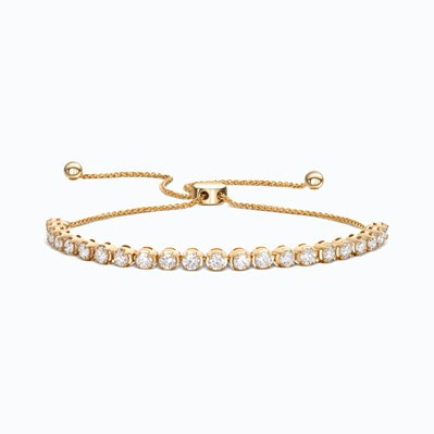 A gold bracelet adorned with diamonds, featuring a secure bolo clasp for adjustable fit and elegance