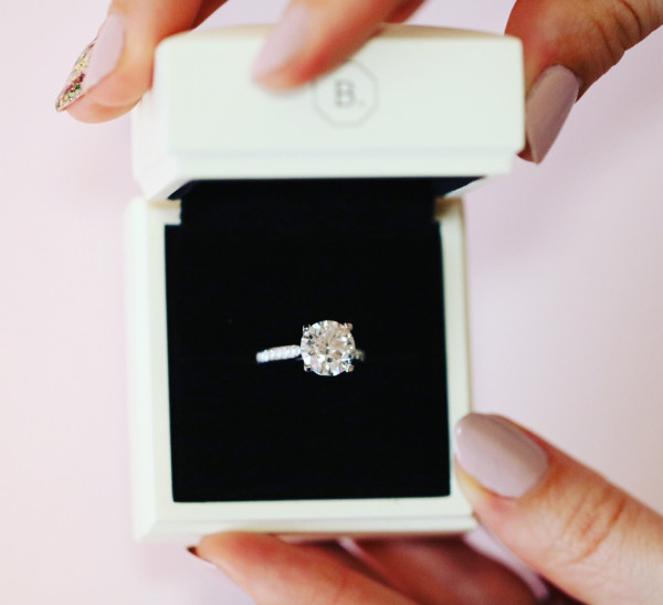 a woman showcasing the wedding ring she bought for her husband, being one of the most important wedding preparations - A diamond engagement ring from BAUNAT