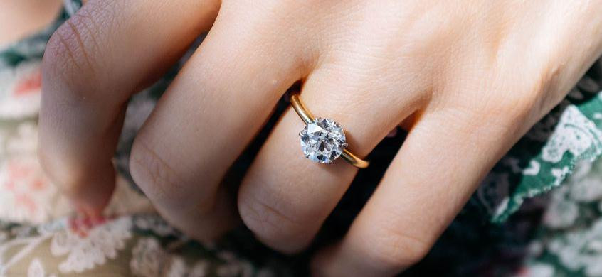 Woman wears yellow gold ring with a brilliant prong setting - BAUNAT
