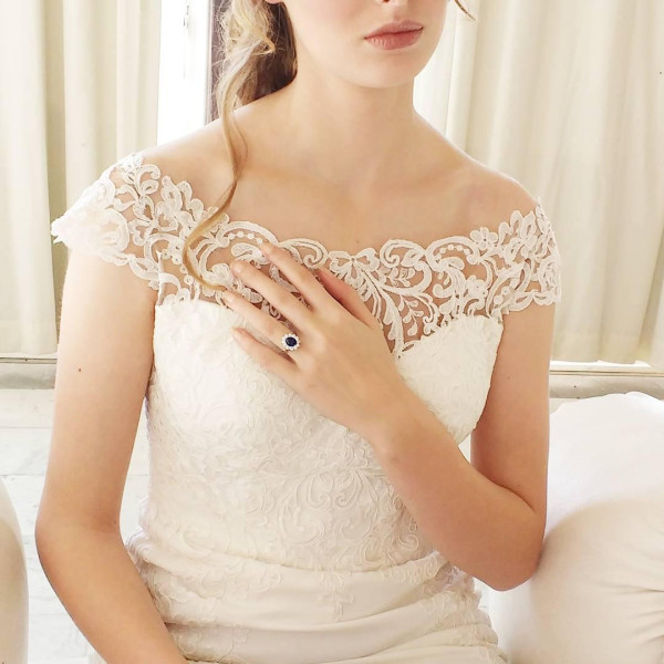 Woman wearing a boat neckline wedding dress with a BAUNAT sapphire entourage ring - boat neckline - dress