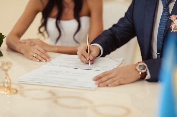 BAUNAT - Couple signing the marriage certificate. Getting married abroad is also legal. – BAUNAT