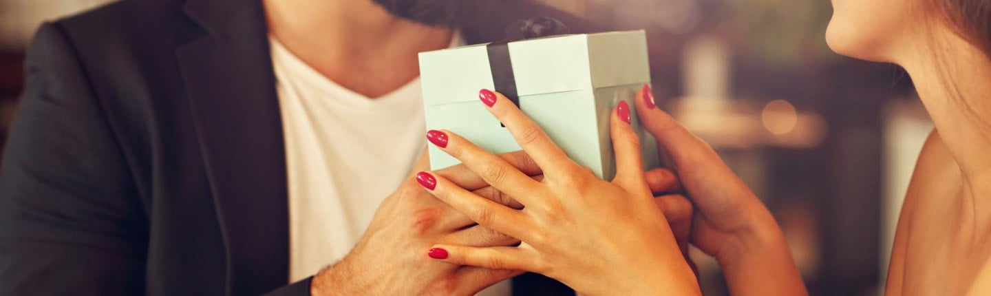 Man gives woman a jewellery gift over dinner - BAUNAT