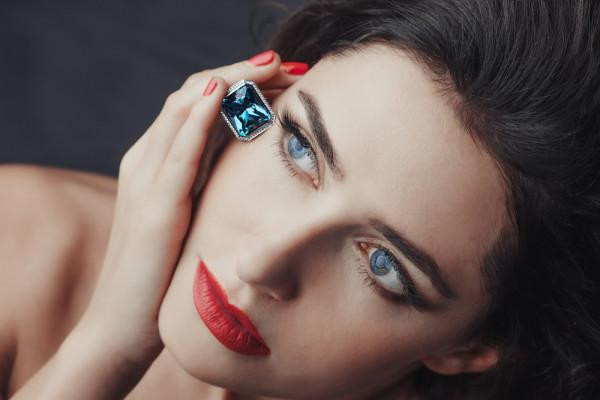 Woman holds jewellery with a blue diamond – BAUNAT