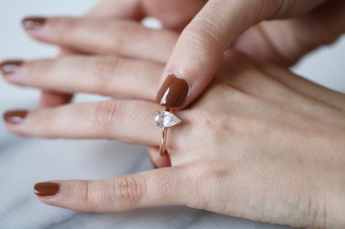 a woman overthinking the size of her engraved engagement ring on her finger